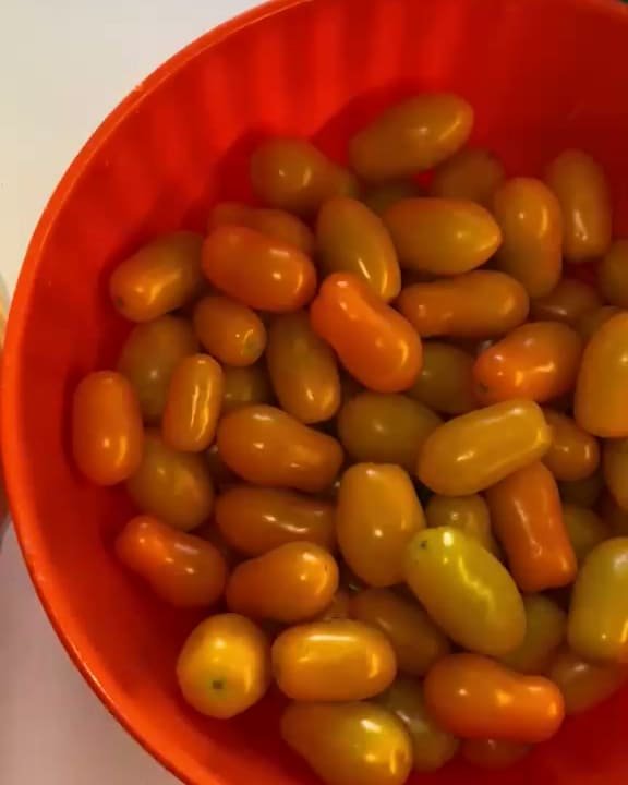 Datterini gialli e arancioni in una bacinella arancione, visti dall'alto