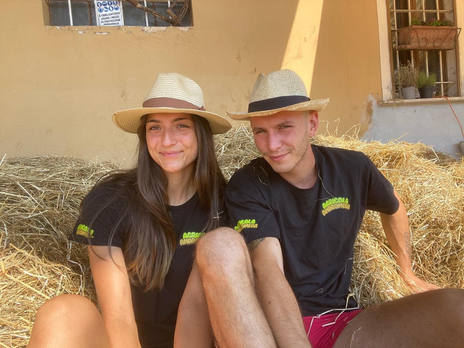 Giorgia e Davide nel campo appena preparato, con in mano una piantina pronta per il trapianto