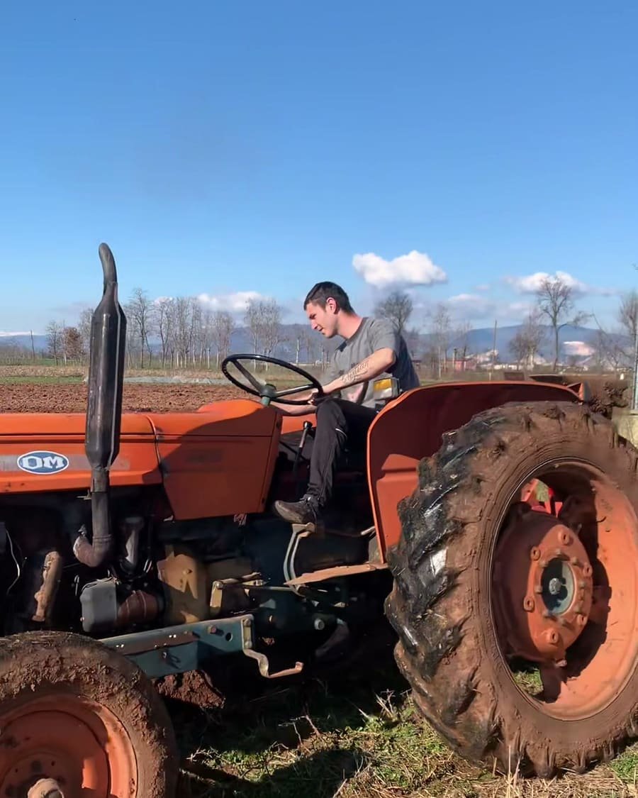 Davide Giaretta al volante del trattore mentre lavora il campo